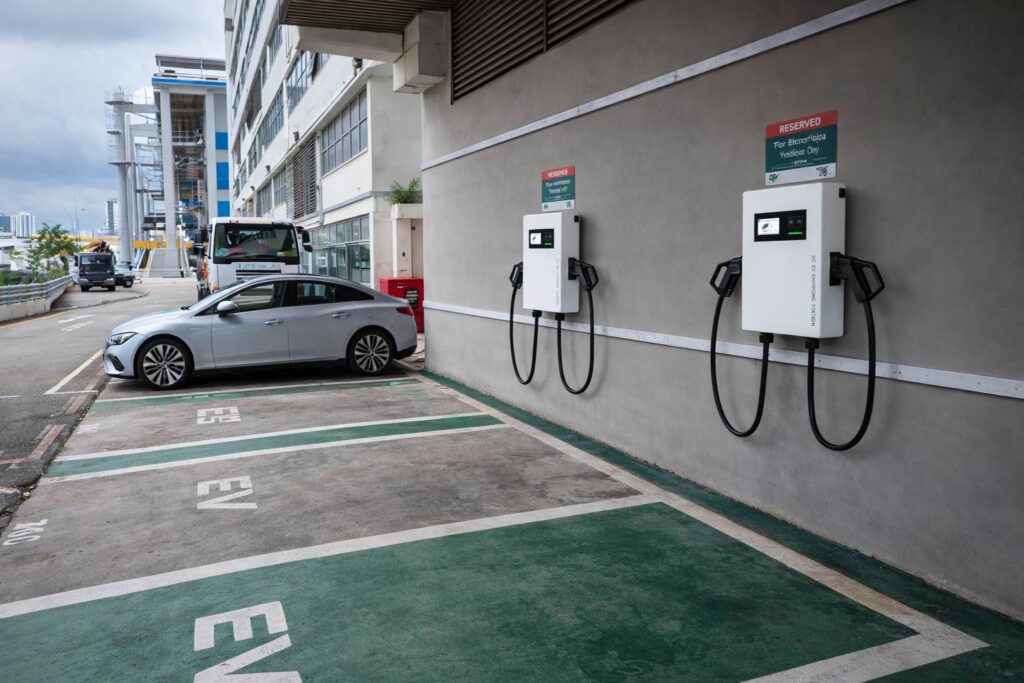 Wall‑mounted DC EV charger at outdoor industrial building parking lot